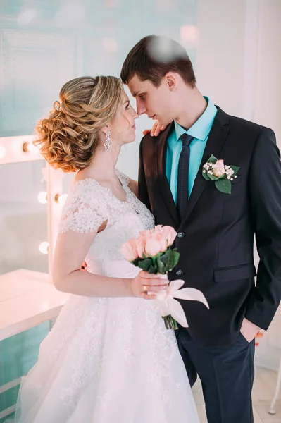 Um casal feliz. Fotografia de casamento atirar no estúdio branco com beijos de decoração de casamento, abraços — Fotografia de Stock