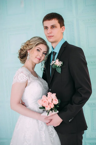 Ευτυχισμένο ζευγάρι. Γαμήλια φωτογράφηση στο λευκό στούντιο με γαμήλια διακόσμηση φιλιά, αγκαλιές — Φωτογραφία Αρχείου