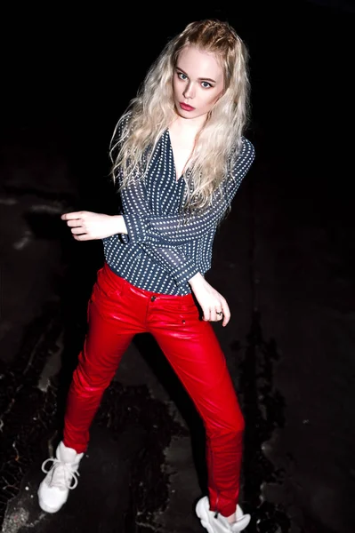 若い幸せな金髪欧州美女夜通りにポーズの屋外のポートレート。スタイリッシュな服の赤いズボンを身に着けているモデルし、ジャンプします。女性のファッション。都市の夜の生活。コピー スペース. — ストック写真