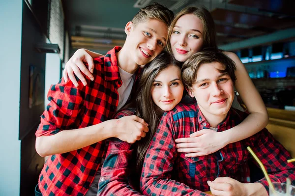 Gruppen av unga vänner umgås på ett kafé. Unga män och kvinnor möte på ett café att ha kul och dricka kaffe. Livsstil, vänskap och stadslivet begrepp. — Stockfoto