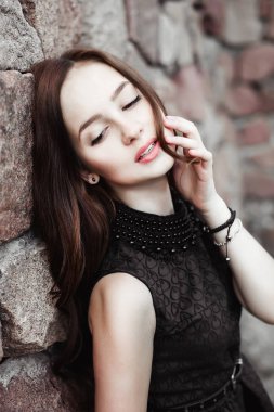 taş duvar arka plan üzerinde güzel üzgün genç kadın