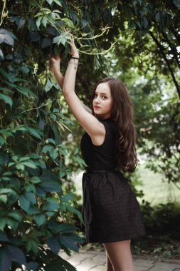 Uzun saçlı, süper sevimli siyah elbiseli güzel genç kız bir