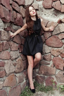 taş duvar arka plan üzerinde güzel üzgün genç kadın