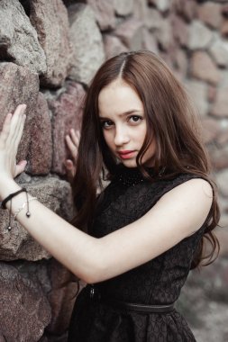 taş duvar arka plan üzerinde güzel üzgün genç kadın