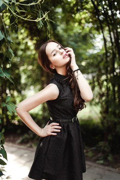 Piękna młoda dziewczyna w czarnej sukni z długimi włosami, milutkie — Zdjęcie stockowe