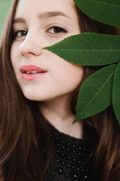 Mooi jong meisje in een zwarte jurk met lange haren, super schattig een — Stockfoto