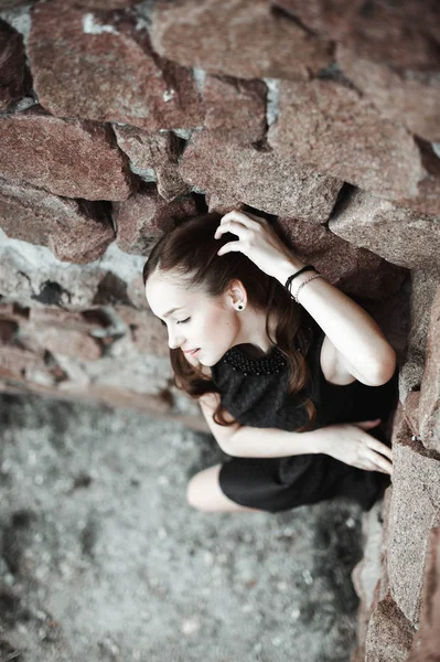 石の壁の背景に美しい悲しい若い女性 — ストック写真