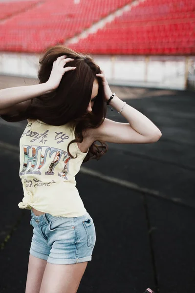 Girl having fun outdoor. Pretty girl sitting at school stadium. — Stock Photo, Image