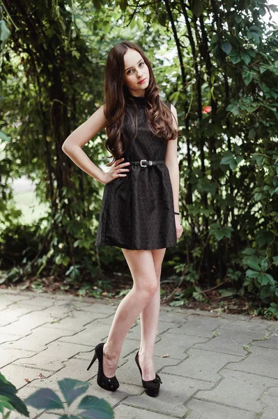 Красива молода дівчина в чорній сукні з довгим волоссям, супер милий — стокове фото