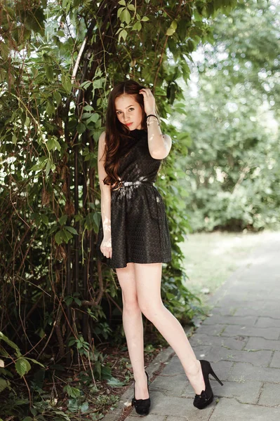 Hermosa joven en vestido negro con el pelo largo, super lindo un — Foto de Stock