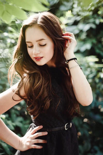 Красива молода дівчина в чорній сукні з довгим волоссям, супер милий — стокове фото