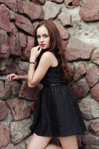 Hermosa mujer joven triste sobre un fondo de pared de piedra — Foto de Stock