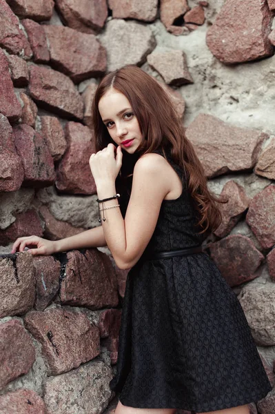 Hermosa mujer joven triste sobre un fondo de pared de piedra — Foto de Stock