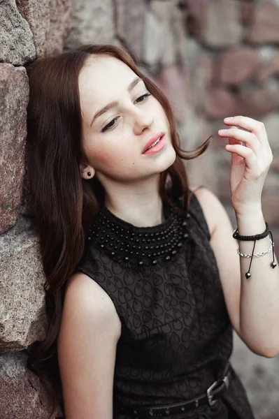 Hermosa mujer joven triste sobre un fondo de pared de piedra — Foto de Stock