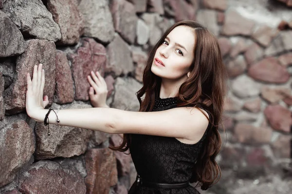 Hermosa mujer joven triste sobre un fondo de pared de piedra — Foto de Stock