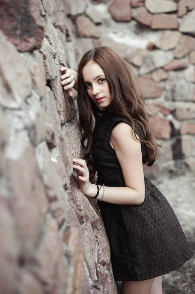 Hermosa mujer joven triste sobre un fondo de pared de piedra — Foto de Stock