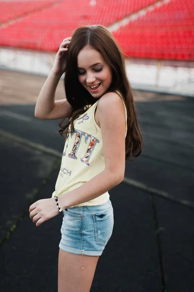 Girl having fun outdoor. Pretty girl sitting at school stadium. — Stock Photo, Image