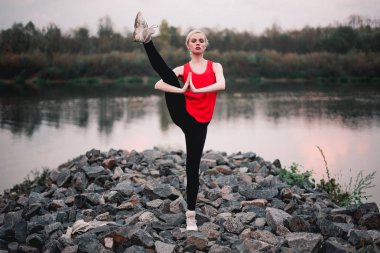 Genç kız Yoga fitness egzersiz nehir manzara açık yapıyor. Akşam günbatımı, Namaste Lotus poz. Meditasyon ve rahatla