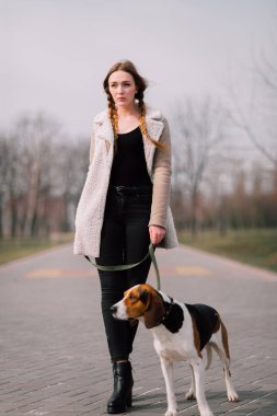 Oynamak ve eğlenmek açık parkta evde beslenen hayvan Estonya tazı köpeği ile genç hippi kız.