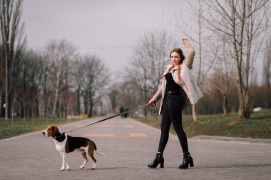 Oynamak ve eğlenmek açık parkta evde beslenen hayvan Estonya tazı köpeği ile genç hippi kız.