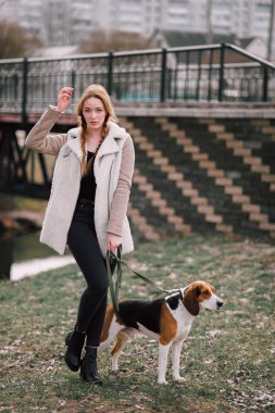 Oynamak ve eğlenmek açık parkta evde beslenen hayvan Estonya tazı köpeği ile genç hippi kız.