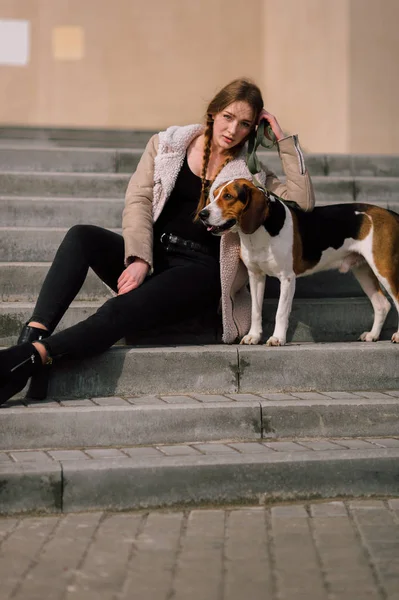 Menina jovem hipster com seu animal de estimação cão de caça estoniano jogando e se divertindo ao ar livre no parque . — Fotografia de Stock