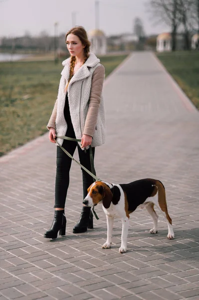 Молода дівчина-хіпстер зі своїм домашнім улюбленцем Естонський собака, який грає і розважається на відкритому повітрі в парку . — стокове фото