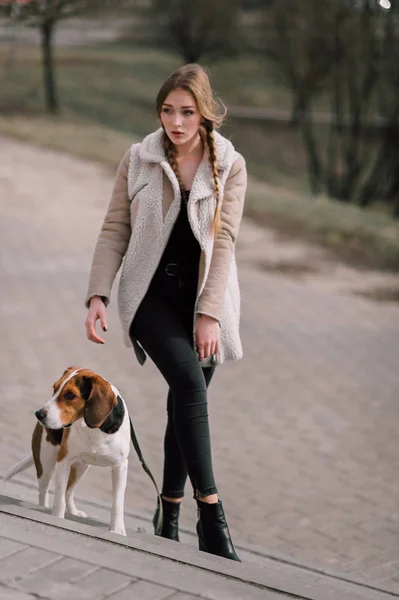 Junges Hipster-Mädchen mit ihrem estnischen Hund, der draußen im Park spielt und Spaß hat. — Stockfoto