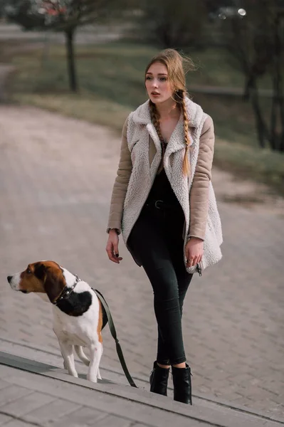 Молодая девушка-хипстер со своей домашней собакой-эстонкой, играющей и развлекающейся на открытом воздухе в парке . — стоковое фото