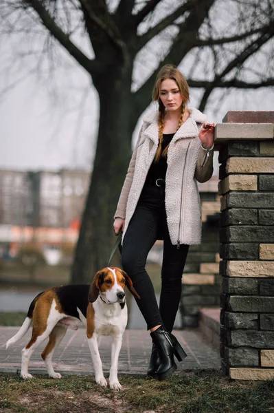 Junges Hipster-Mädchen mit ihrem estnischen Hund, der draußen im Park spielt und Spaß hat. — Stockfoto