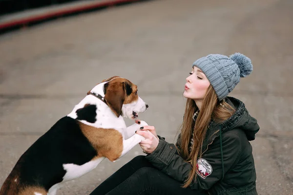 Unga hipster flicka med hennes husdjur estniska hund hund spelar, junping och kramas och att ha kul utomhus på den gamla stadionen. — Stockfoto