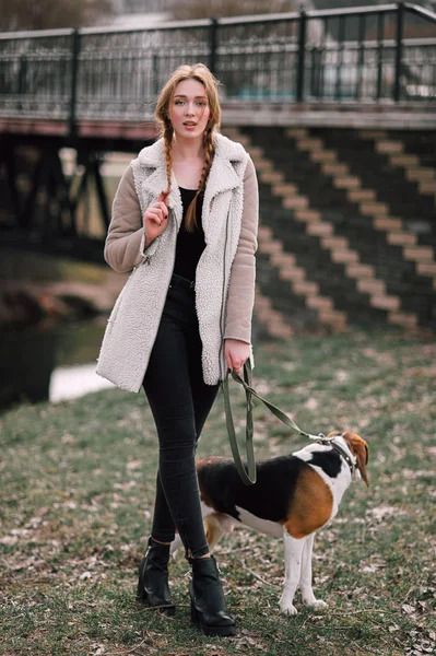 流行に敏感な若い少女と遊んで、公園で屋外楽しんでペット エストニアン ・ ハウンド犬. — ストック写真