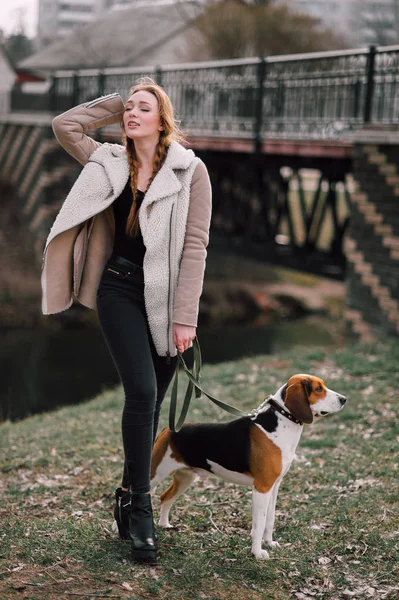 Молода дівчина-хіпстер зі своїм домашнім улюбленцем Естонський собака, який грає і розважається на відкритому повітрі в парку . — стокове фото