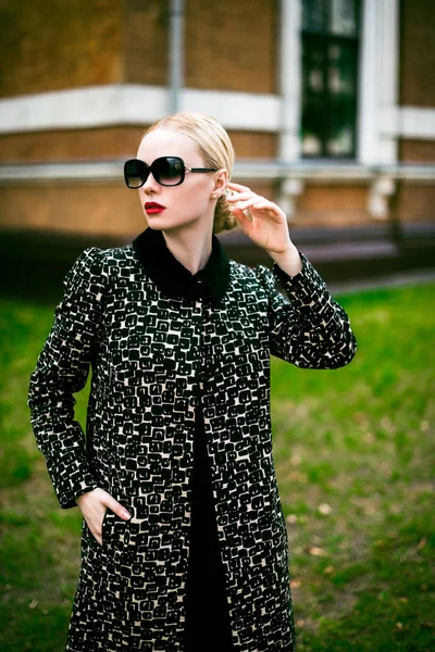 Bir ceket ve yükseklik topuklar ve eski tuğla bina yakın poz gözlük siyah kıvırcık saçlı seksi güzel kadın moda sonbahar açık fotoğrafı