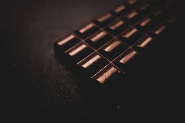 Chocolate na mesa de madeira no fundo escuro — Fotografia de Stock