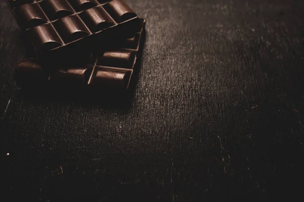 어두운 배경에 나무 테이블에 초콜릿 — 스톡 사진