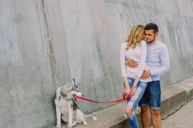 Güzel genç çift bir parkta husky köpeğiyle oynuyor. Summe