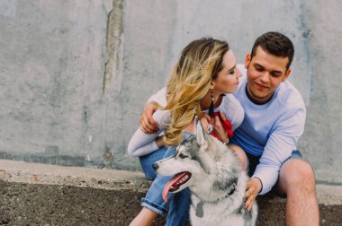 Güzel genç çift bir parkta husky köpeğiyle oynuyor. Summe