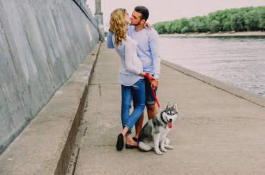 Güzel genç çift bir parkta husky köpeğiyle oynuyor. Summe