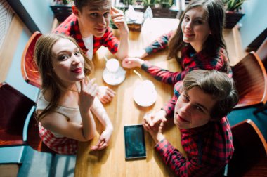 Grup genç arkadaşlar bir kahve dükkanında dışarı asılı. Genç erkek ve kadınların bir kafede kahve içme ve eğlenmek tanışmak. Yaşam tarzı, dostluk ve kentsel yaşam kavramları.