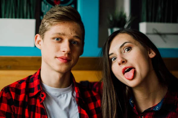 Un grupo de jóvenes amigos pasando el rato en una cafetería. Hombres y mujeres jóvenes que se reúnen en un café divirtiéndose y tomando café. Conceptos de estilo de vida, amistad y vida urbana . — Foto de Stock