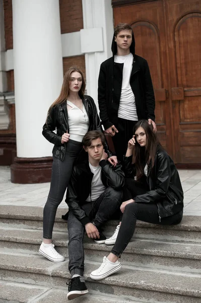 Jóvenes elegantes amigos de moda al aire libre, con ropa en blanco y negro — Foto de Stock