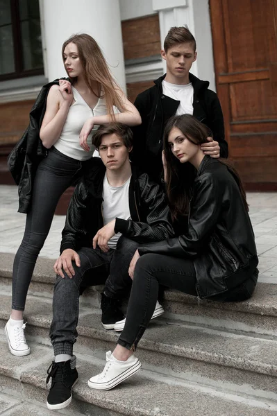 Jóvenes elegantes amigos de moda al aire libre, con ropa en blanco y negro — Foto de Stock