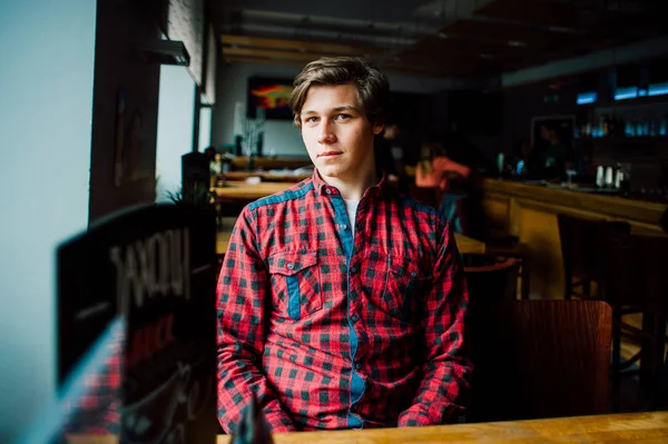 Gruppen av unga vänner umgås på ett kafé. Unga män och kvinnor möte på ett café att ha kul och dricka kaffe. Livsstil, vänskap och stadslivet begrepp. — Stockfoto