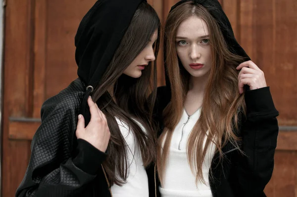 Elegante trendy meisjes buitenshuis, zwarte en witte kleding dragen — Stockfoto