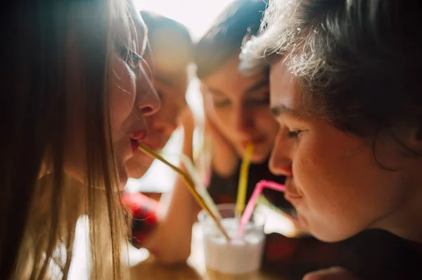 Um grupo de jovens amigos numa cafetaria. Jovens homens e mulheres que se encontram em um café se divertindo e bebendo café. Estilo de vida, amizade e conceitos de vida urbana . — Fotografia de Stock