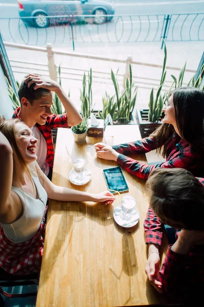 Groupe de jeunes amis qui traînent dans un café. Jeunes hommes et femmes se réunissant dans un café pour s'amuser et boire du café. Style de vie, amitié et concepts de vie urbaine . — Photo