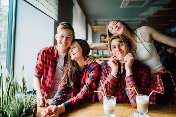 Groep jonge vrienden opknoping uit bij een coffeeshop. Jonge mannen en vrouwen ontmoeten in een cafe met plezier en koffie drinken. Lifestyle, vriendschap en stadsleven concepten. — Stockfoto
