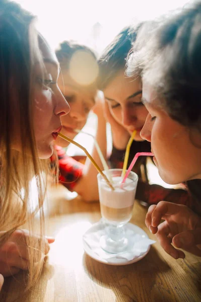 Gruppe junger Freunde, die in einem Café abhängen. Junge Männer und Frauen treffen sich in einem Café, unterhalten sich und trinken Kaffee. Lebensstil, Freundschaft und urbane Lebenskonzepte. — Stockfoto