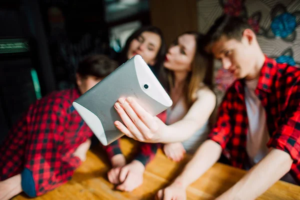 Un grupo de jóvenes amigos pasando el rato en una cafetería. Hombres y mujeres jóvenes que se reúnen en un café divirtiéndose y tomando café. Conceptos de estilo de vida, amistad y vida urbana . — Foto de Stock